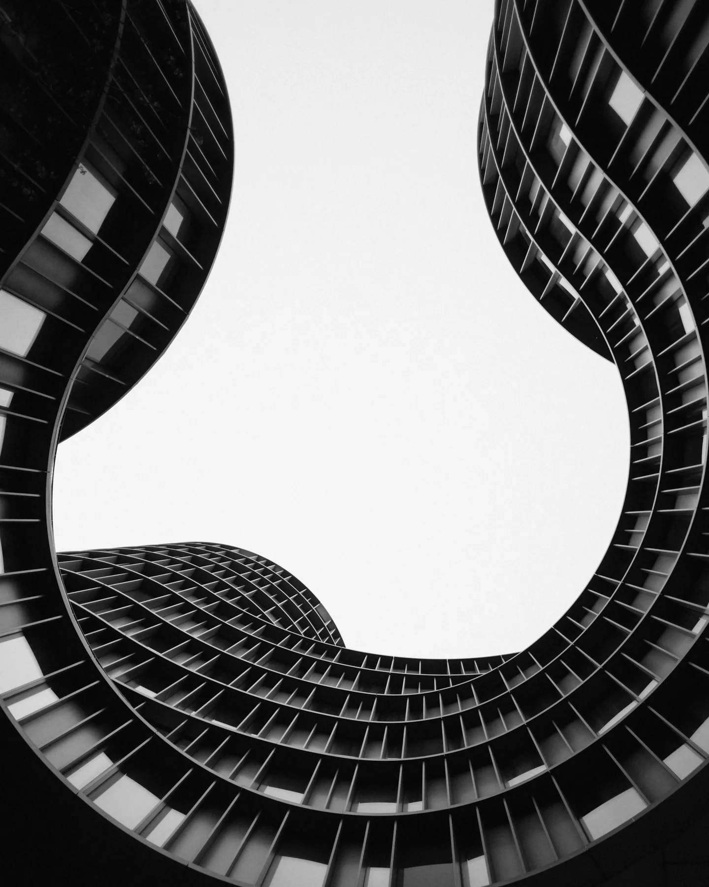 Curved modern buildings framing an open sky