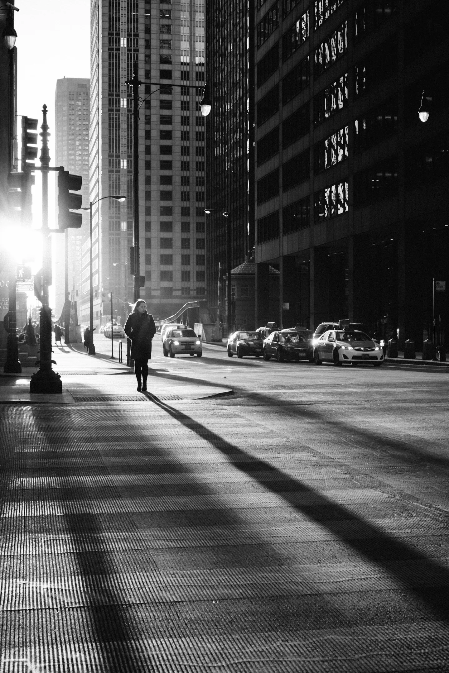 Pedestrian casting a long shadow on a downtown street