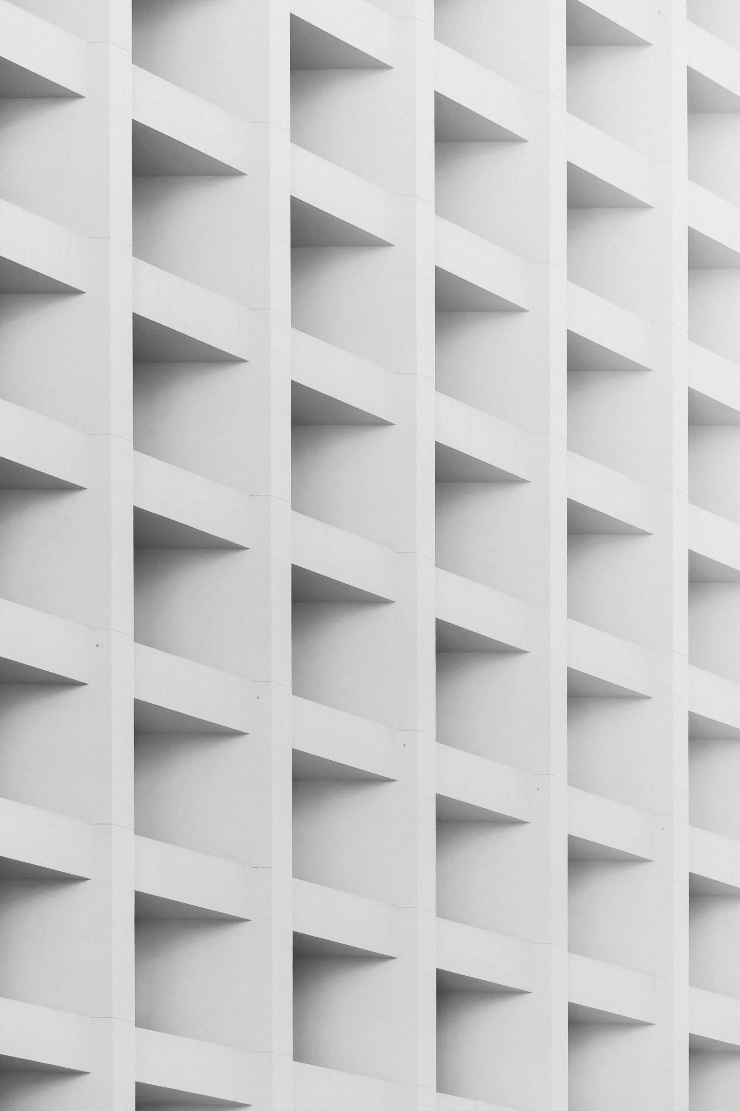 Repeating geometric openings across a pale facade