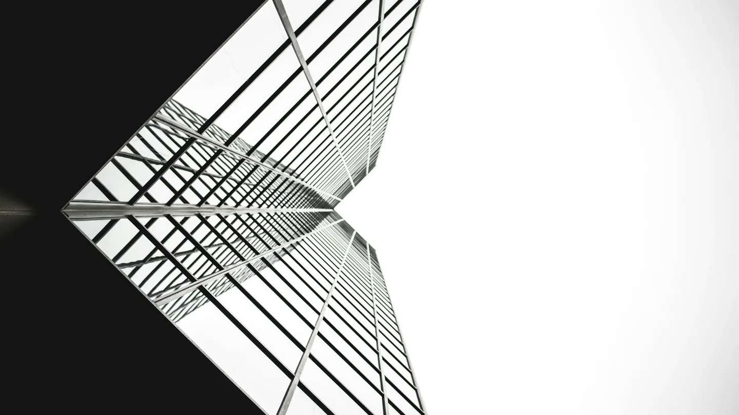 Angular glass facade disappearing into white sky