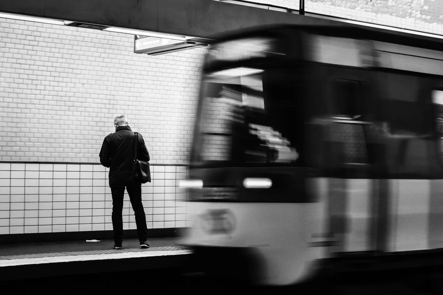 Commuter standing beside a blurred metro train
